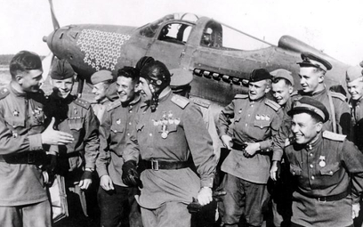 Oficerowie radzieckiego lotnictwa wojskowego w bazie lotniczej. W tle: amerykański P-39 Aircobra dos