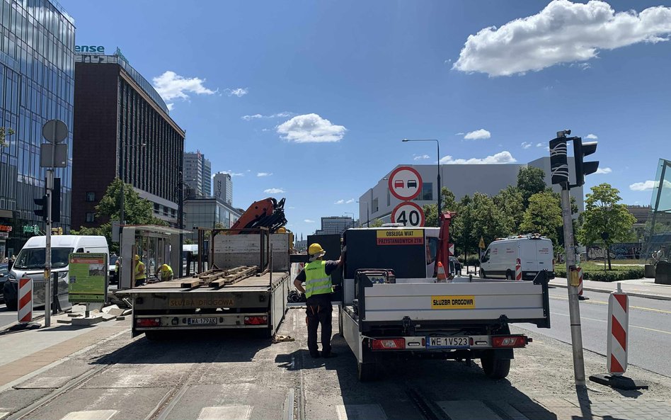 Robotnicy w żółtych kamizelkach pracują przy fragmencie torowiska tramwajowego