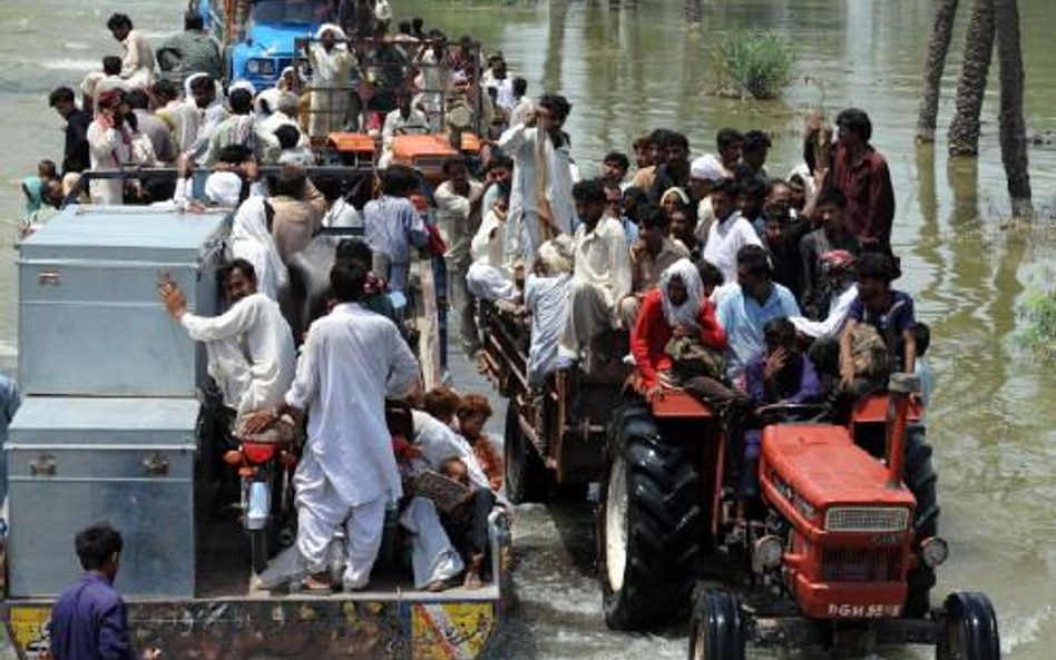 Pakistan, Bassera. Rodziny poszkodowane przez powódź wracają do swoich zalanych domów