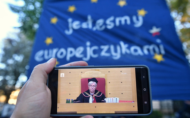 Prezes Trybunału Konstytucyjnego Julia Przyłębska podczas obrad oglądanych na ekranie smartfona prze