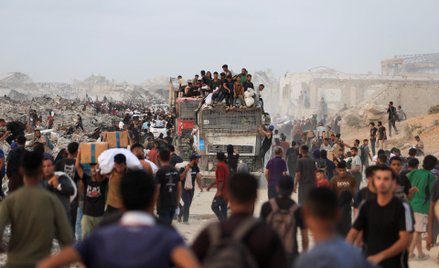 Palestyńczycy gromadzą się wokół ciężarówek z pomocą humanitarną, które dotarły do Strefy Gazy. Bajt