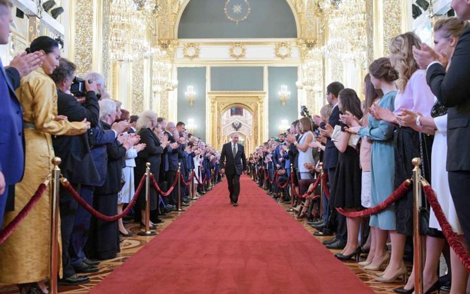 Tłum urzędników oklaskuje Władimira Putina w drodze na ceremonię zaprzysiężenia.