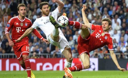 Real przyjechał do Niemiec z jednobramkową zaliczką. O piłkę walczą Xabi Alonso (w środku) i Thomas 