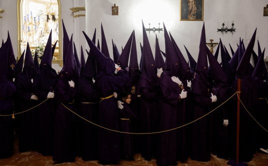 Członkowie Bractwa Padre Jesus, pełniący rolę pokutników, czekają w kościele na procesję w Wielkim T