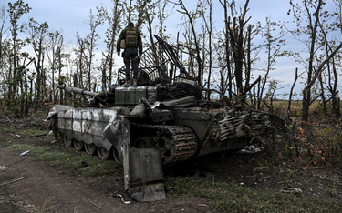 Ukraiński żołnierz na zniszczonym rosyjskim czołgu