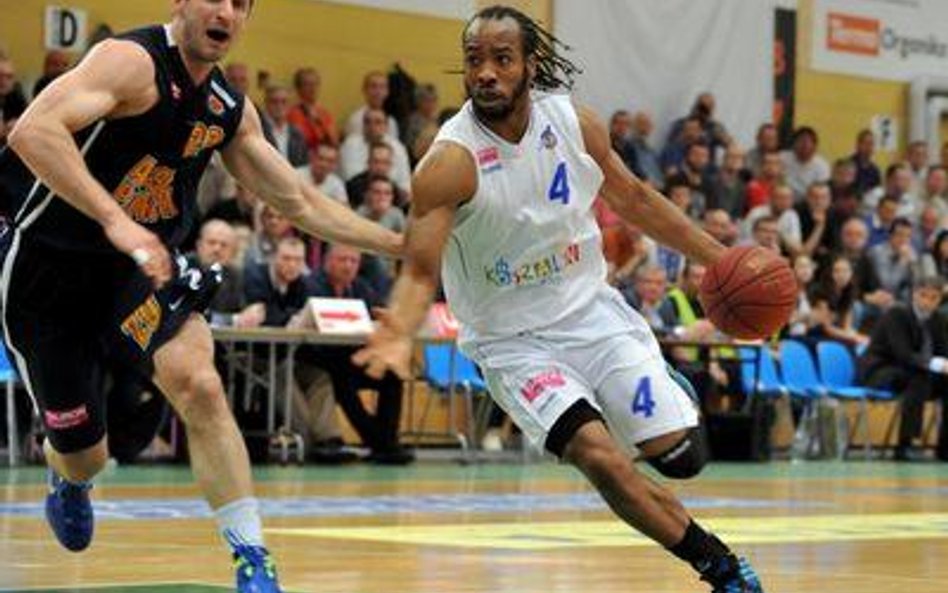 Koszykarz AZS Koszalin Jeremy Montgomery mija Piotra Szczotkę z Asseco Prokom Gdynia