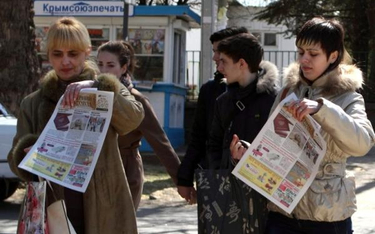 Mieszkanki Krymu pokazują gazety ze zdjęciem paszportu rosyjskiego. Mieszkańcy Krymu mają miesiąc na