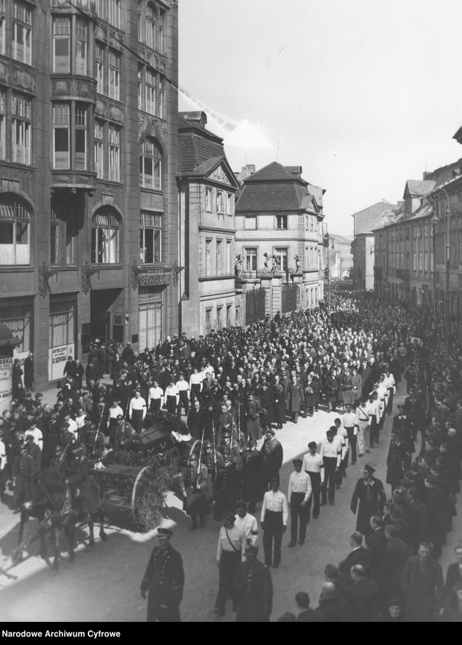 Kondukt pogrzebowy podczas pochodu ul. Długą. Na pierwszym planie widoczna trumna na lawecie eskorto