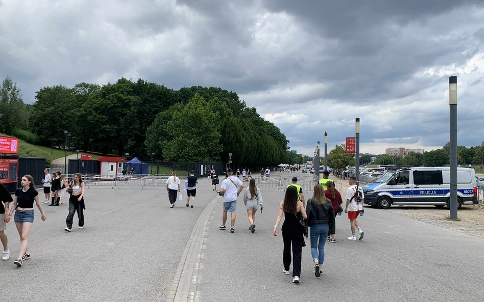 Widok na tereny wokół stadionu, gdzie gromadzą się uczestnicy koncertu, w oddali widoczny radiowóz p
