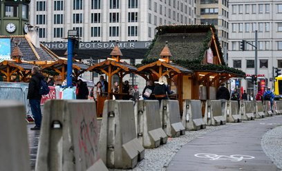 Betonowe bloki stoją wokół jarmarku bożonarodzeniowego „Winterwelt Potsdamer Platz Berlin”, który je