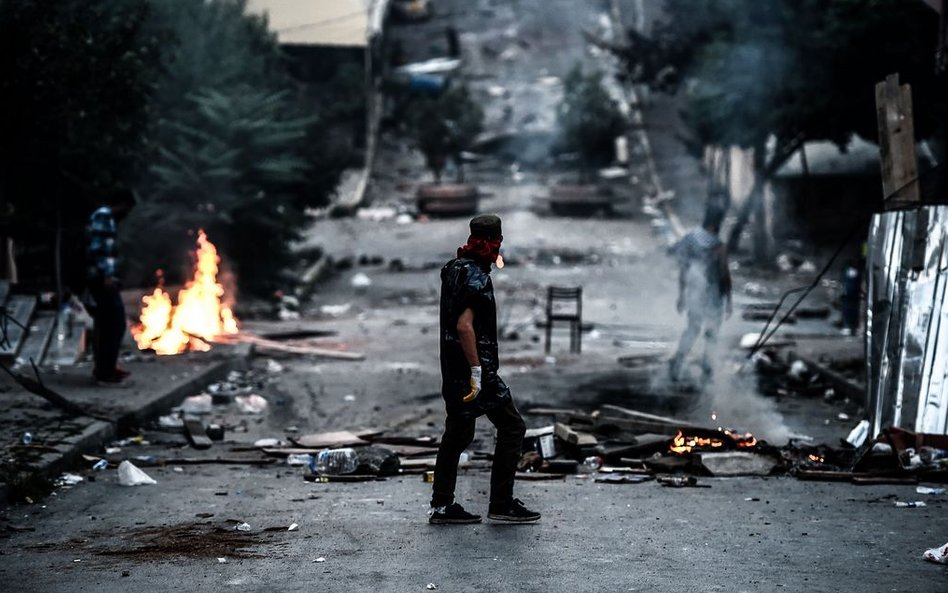 Jeden z protestujących stojący przed barykadą podczas starć z policją w trakcie zamieszek w Stambule