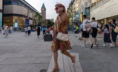 Kobieta spaceruje ulicą Wangfujing w Pekinie