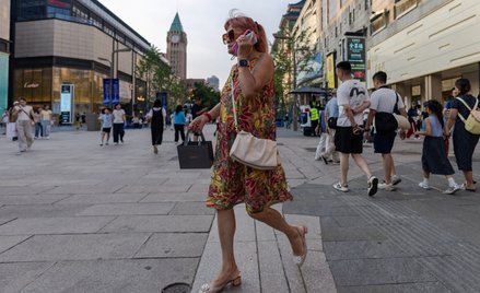 Kobieta spaceruje ulicą Wangfujing w Pekinie