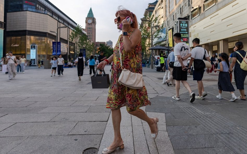 Kobieta spaceruje ulicą Wangfujing w Pekinie
