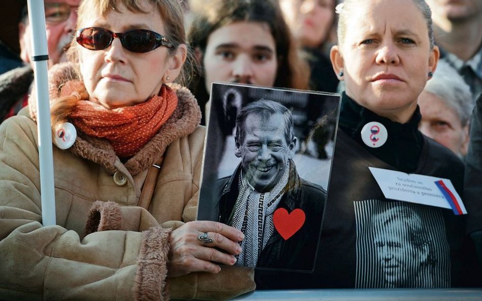 Na ubraniach – znaczki z klepsydrą, w ręku – portret Vaclava Havla. Demonstranci w Pradze, 16 listop