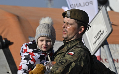 Polski żołnierz niesie ukraińskie dziecko, przejście graniczne w Medyce, fotografia z 14 marca