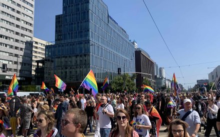 Uczestnicy wypełniają ulicę, niosąc ze sobą dziesiątki tęczowych flag
