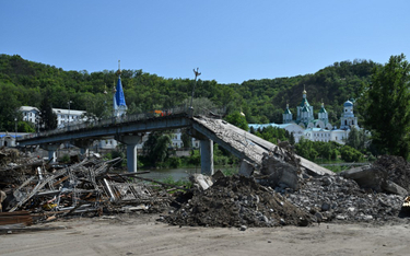 Robotnicy oczyszczają z gruzu zniszczony most obok prawosławnego klasztoru w Swiatogorsku w obwodzie