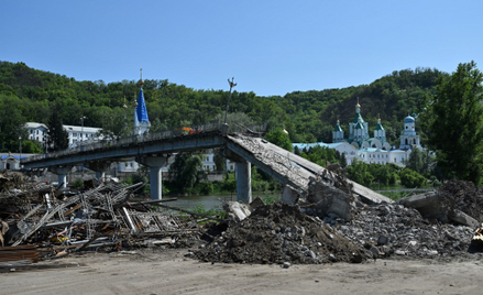 Robotnicy oczyszczają z gruzu zniszczony most obok prawosławnego klasztoru w Swiatogorsku w obwodzie