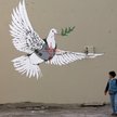 Betlejem na Zachodnim Brzegu. Palestyński chłopiec ogląda pracę Banksy’ego, brytyjskiego artysty uli