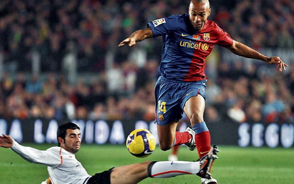Thierry Henry (próbuje go zatrzymać Raul Albiol) strzelił trzy gole, a Barcelona wygrała z Valencią 