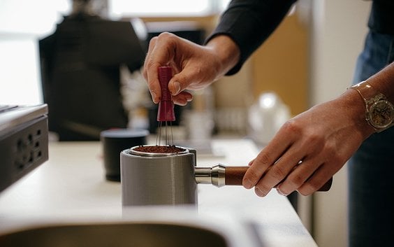 Proces parzenia espresso. Fusy umieszczane są w komorze parzenia (ubijaku), grudki są usuwane za pom