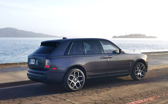 Rolls-Royce Cullinan Black Badge. W tle po prawej Alcatraz