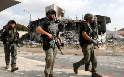 Izraelskie siły bezpieczeństwa przed zniszczonym budynkiem policji w mieście Sederot w pobliżu Stref