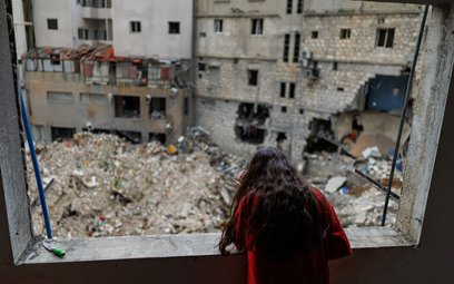 12-letnia Alaa Dahnoun, która przeżyła izraelskie bombardowanie, wygląda z okna swego mieszkania w B