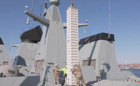 Umieszczanie pojemnika z pociskiem SM-2 w pionowej wyrzutni Mk 41 VLS na śródokręciu fregaty.