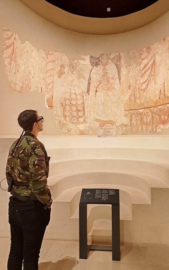 Student archeologii analizuje malowidło z Galerii Faras w Warszawie mając założony eye-tracker okula