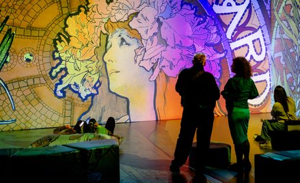 Znakiem rozpoznawczym Alfonsa Muchy są grafiki przedstawiające wyidealizowane postacie kobiet otoczo