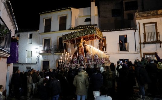 Ludzie obserwują, jak „costaleros” niosą figurę Matki Boskiej na konstrukcji tradycyjnie zwanej „pas