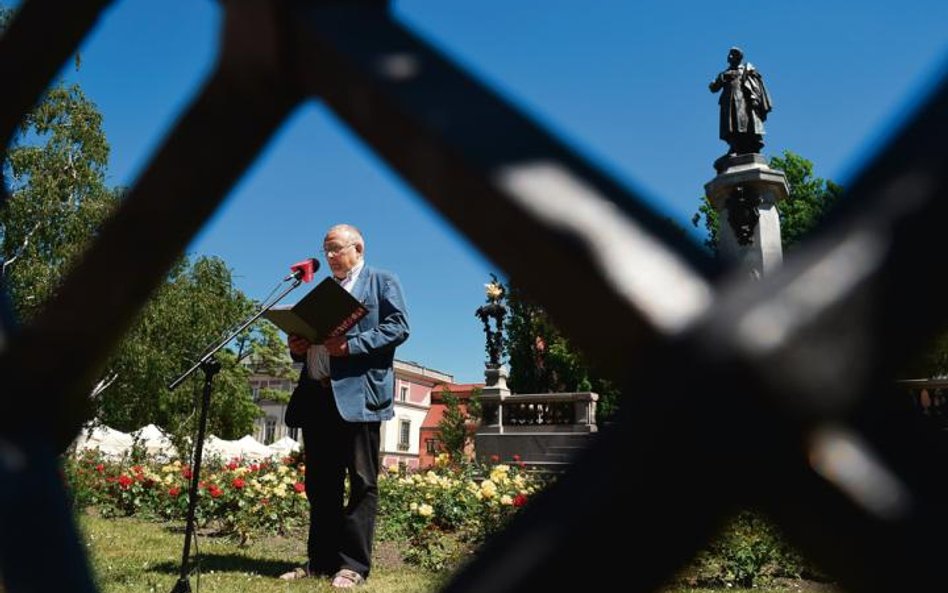 Adam M. u stóp pomnika Adama M. stopy tym razem w sandałach