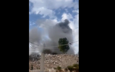 Kadr z nagrania na którym widać słup dymu po ataku w rejonie lotniska w Damaszku