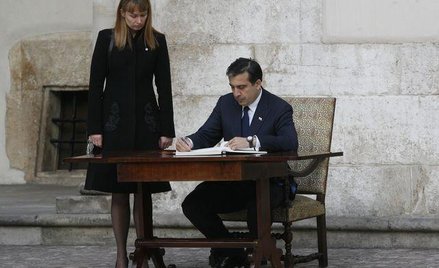 Prezydent Saakaszwili wpisuje się do księgi kondolencyjnej na Wawelu