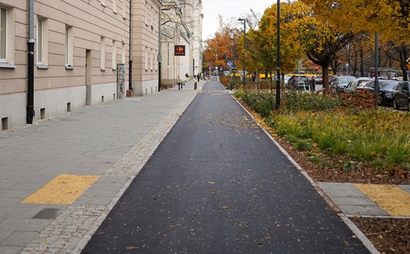 Ten sam odcinek ścieżki rowerowej wzdłuż ulicy Anielewicza po remoncie, gładka asfaltowa powierzchni