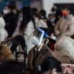 Pasażerka w masce i przyłbicy na dworcu w Wuhan
