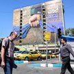 Irańczycy przechodzą obok dużego billboardu nawiązującego do Cieśniny Ormuz na placu Vanak w Teheran