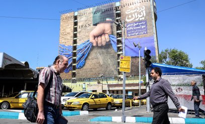 Irańczycy przechodzą obok dużego billboardu nawiązującego do Cieśniny Ormuz na placu Vanak w Teheran