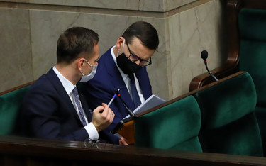Premier Mateusz Morawiecki (P) na sali plenarnej Sejmu w Warszawie