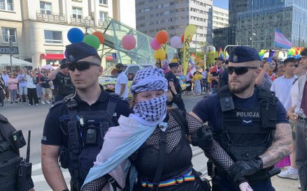 Jeden z protestujących, który z własnej woli zszedł z ciężarówki, stoi w asyście policjantów.