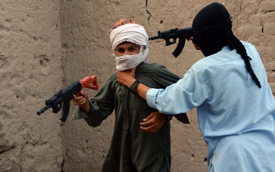 Afgańskie dzieci bawiące się plastikową bronią.