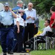 Pielęgniarz Roger Kingsley Dean, w otoczeniu policji, z maską tlenową na twarzy po pożarze w domu op