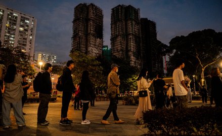 Kolejka osób, chcących złożyć kwiaty dla upamiętnienia ofiar pożaru na osiedlu Wang Fuk Court w dzie