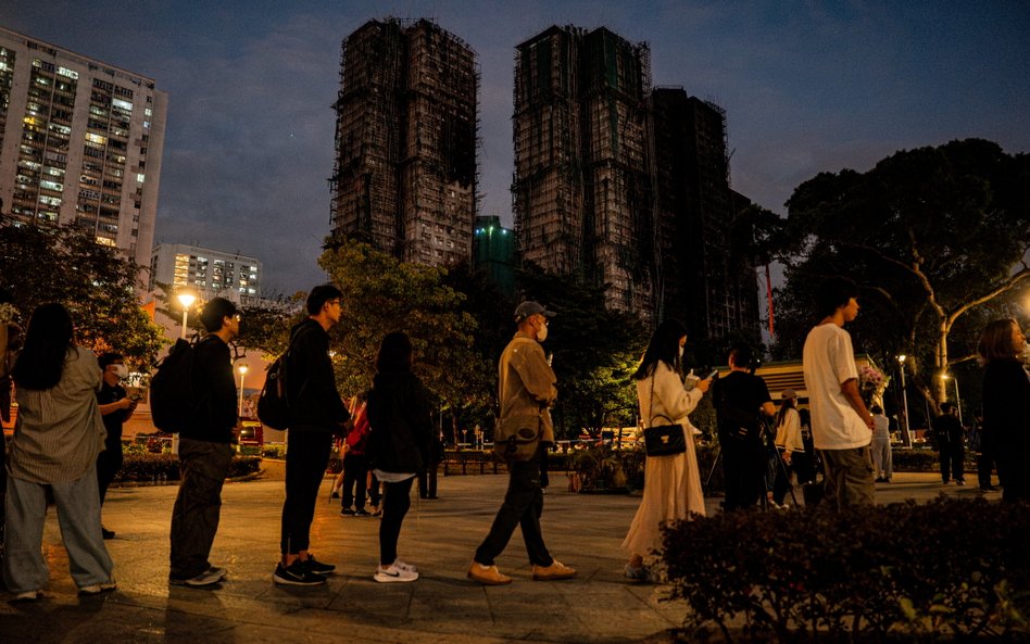 Kolejka osób, chcących złożyć kwiaty dla upamiętnienia ofiar pożaru na osiedlu Wang Fuk Court w dzie