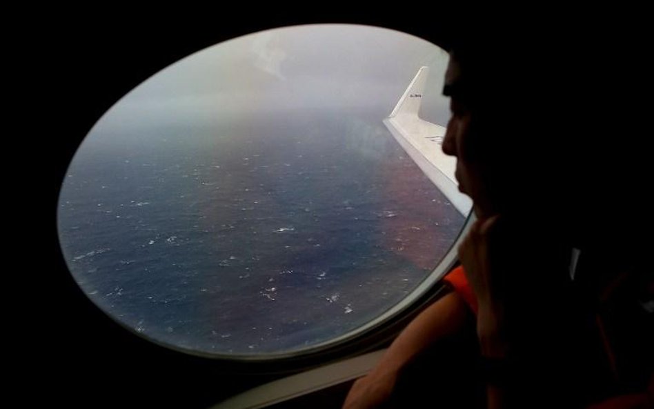 Jeden z członków japońskiej straży przybrzeżnej z pokładu samolotu wypatruje szczątków samolotu MH37