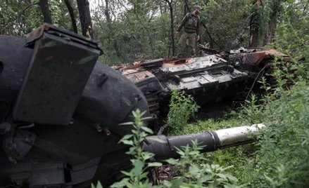 Ukraiński żołnierz przy zniszczonym rosyjskim czołgu