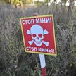 Zdjęcie tablicy z napisem „Stop, miny” na polu minowym we wsi Grakowo w obwodzie charkowskim