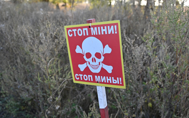 Zdjęcie tablicy z napisem „Stop, miny” na polu minowym we wsi Grakowo w obwodzie charkowskim